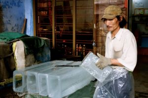 pracovník v rodinné továrně na led v Nam O ve Vietnamu