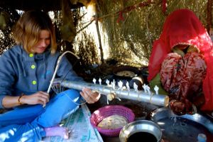 Bo on the road se pokouší hrát na tradiční nástroj ravnhattha, Rajasthan, India.