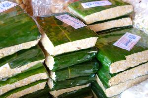 Fresh tempeh sold in a banana leaf at traditional market in Bali, Indonesia by Authentic World Food