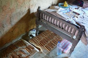 sušení kůry skořice pod postelí v hliněném domku na Srí Lance