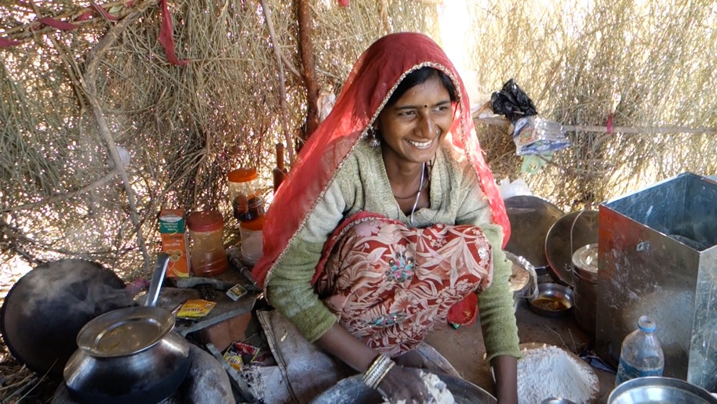 beautifully decorated gipsy woman making chapati in Pushkar, India