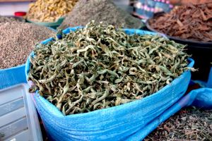 Prodej sušené citrónové verbeny z pytlů na tradičním marockém tržišti souk