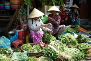 Fresh herbs vendors on traditional Vietnamese market in Vietnam - by Authentic World Food