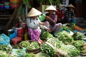 Fresh herbs vendors on traditional Vietnamese market in Vietnam - by Authentic World Food